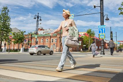 Пермь. Женщина переходит дорогу по пешеходному переходу.