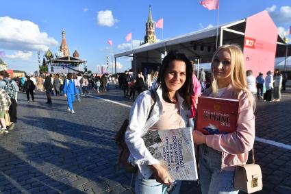 Москва. Девушки с книгами ИД `Комсомольская правда` `Главные документы Великой Отечественной войны` и `Спецоперация Крым-2014` Виктора Баранца на VIII книжном фестивале `Красная площадь `.