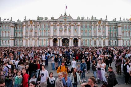 Санкт-Петербург.  Молодые люди на Дворцовой площади перед началом праздника  выпускников`Алые паруса`.