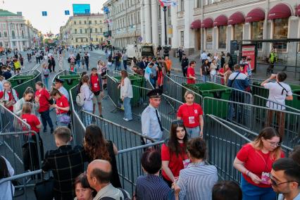 Санкт-Петербург. Молодые люди проходят через ограждения во время праздника выпускников `Алые паруса`.