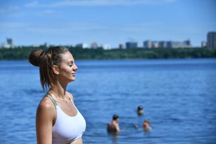 Москва.  Девушка загорает на пляже в Строгино.