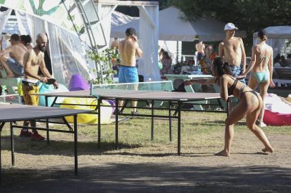 Москва.  Отдыхающие играют в настольный теннис  на пляже.