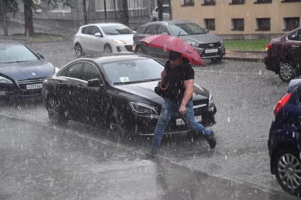 Москва.  Мужчина переходит улицу  во время дождя.