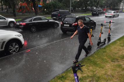 Москва.  Мужчина без зонта на улице  во время дождя.