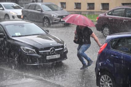 Москва.  Мужчина переходит улицу  во время дождя.