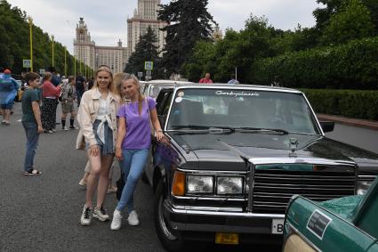 Москва. Девушки у ретроавтомобиля `ЗИЛ` на Воробьевых горах во время фестиваля `Ретрорейс` в рамках празднования Дня московского транспорта.
