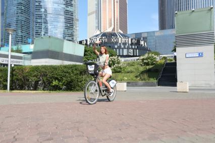 Москва.   Девушка на велосипеде на Пресненской набережной.