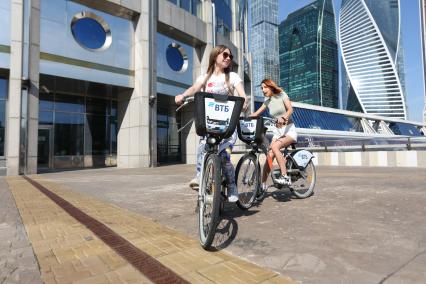Москва.   Девушки на велосипедах на Пресненской набережной.
