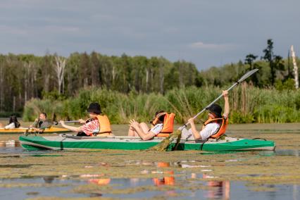 Москва. Отдыхающие во время сплава на байдарках по Верхнеяузскому водно-болотному комплексу в национальном парке `Лосиный остров`.