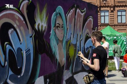 Владивосток. Юноша рисут граффити на стене во время празднования Дня молодежи.