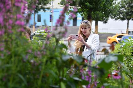 Москва. Женщина фотографирует цветы во время фестиваля \"Цветочный джем: тропическое лето\"