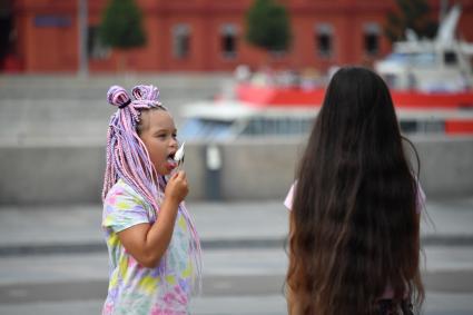 Москва. Девочки едят мороженое  в жаркую погоду   в Парке искусств Музеон .