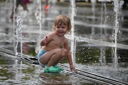 Москва.  Ребенок  играет в жаркую погоду у Сухого фонтана в Парке искусств Музеон .