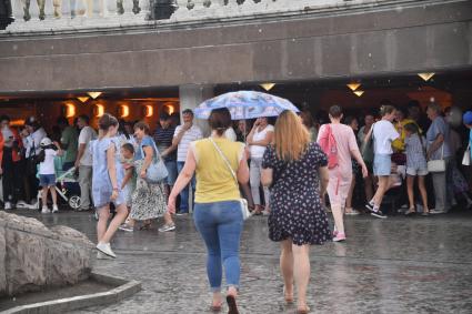 Москва.  Прохожие в Александровском саду во время дождя.