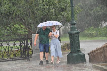 Москва.  Прохожие в Александровском саду во время дождя.