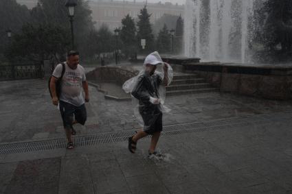 Москва.  Прохожие в Александровском саду во время дождя.