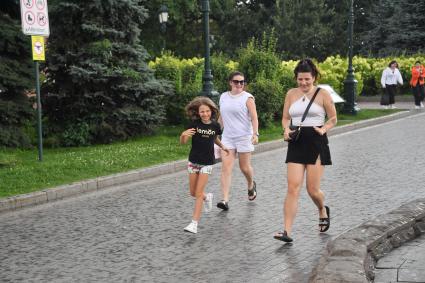 Москва. Прохожие в Александровском саду во время дождя.
