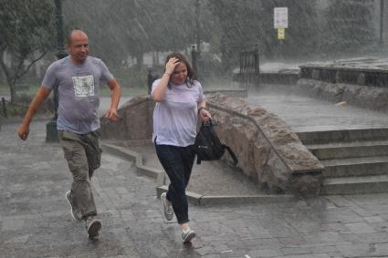 Москва.  Прохожие в Александровском саду во время дождя.