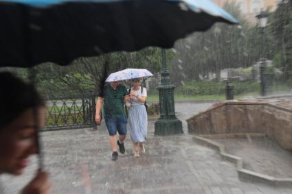 Москва.  Прохожие в Александровском саду во время дождя.