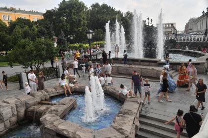 Москва.  Люди у фонтанов на Манежной полщади.