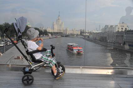 Москва. Ребенок  в коляске на Парящем мосту парка Зарядье.