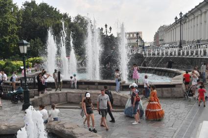 Москва.  Люди у фонтанов на Манежной полщади.