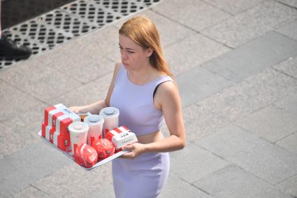 Москва.  Девушка несет еду из кафе быстрого питания KFC.