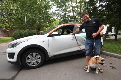 Москва. Корреспондент `Комсомольской правды` Олег Адамович с собакой у автомобиля сервиса каршеринга `Делимобиль`.