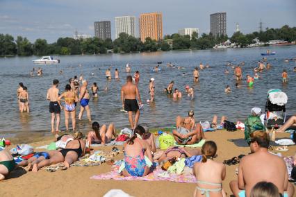 Москва. Люди загорают на пляже Косинского озера.