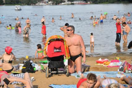 Москва. Люди загорают на пляже Косинского озера.