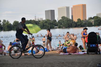 Москва. Люди загорают на пляже Косинского озера.