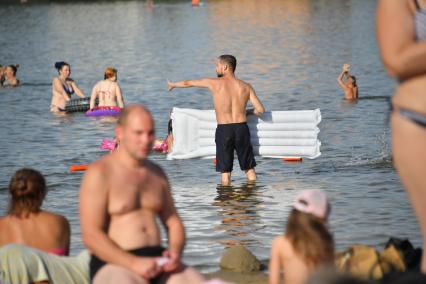 Москва. Мужчина с надувным матрасом на пляже в Косино.