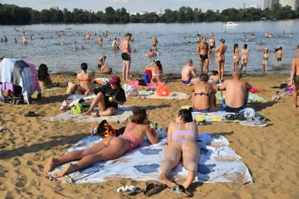 Москва. Люди загорают на пляже Косинского озера.