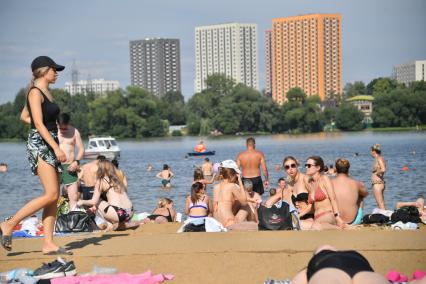 Москва. Люди загорают на пляже Косинского озера.