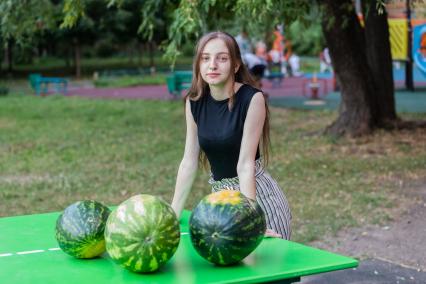 Москва. Девушка выбирает арбуз.