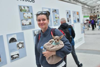 Москва. Девушка с собачкой на руках на 35-ой Московской международной книжной ярмарке в выставочном комплексе `Гостиный Двор`.