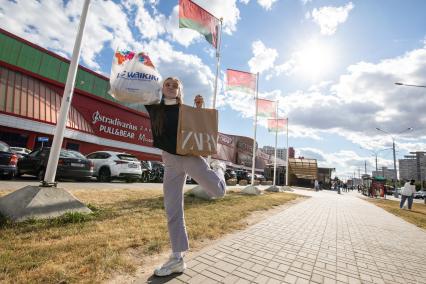 Беларусь. Минск. Девушка с покупками у торгового центра.