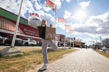 Беларусь. Минск. Девушка с  покупками у  торгового центра.