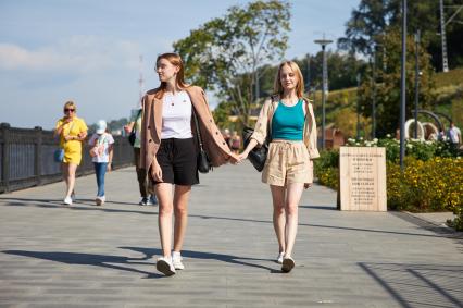 Пермь. Девушки взявшись за руки гуляют по улице.