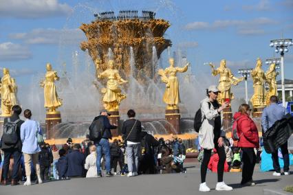 Москва.  Люди гуляют у фонтана   `Дружба народов` на ВДНХ во время празднования Дня города.