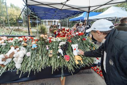 Ижевск. Люди приносят цветы к стихийному мемориалу у школы #88, где 26 сентября 2022 г. в результате стрельбы погибли 17 человек.