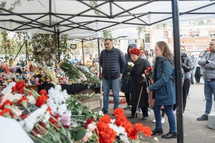 Ижевск. Люди приносят цветы к стихийному мемориалу у школы #88, где 26 сентября 2022 г. в результате стрельбы погибли 17 человек.