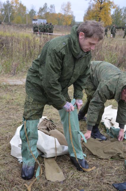 Московская область. Мобилизованные мужчины, проходящие боевую подготовку на полигоне, одевают огнестойкие костюмы, защищающие от дронов. Президент РФ 21 сентября подписал указ о проведении в стране частичной мобилизации.