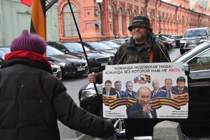 Москва. Участник Национально-освободительного движения (НОД) с плакатами и флагами в центре города.