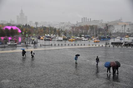 Москва.  Прохожие на Васильевском спуске во время дождя.