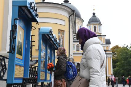 Москва. Прихожанки у стеда с иконой Святой Матроны Московской и святых мест на территории Покровского женского монастыря.