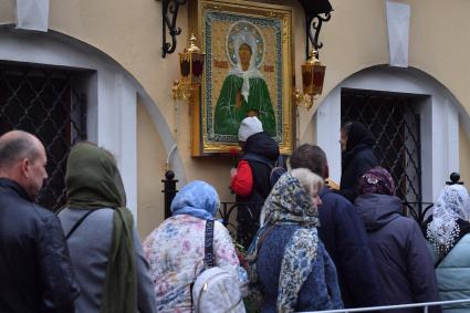 Москва. Прихожане у иконы Святой Матроны Московской на территории Покровского женского монастыря.