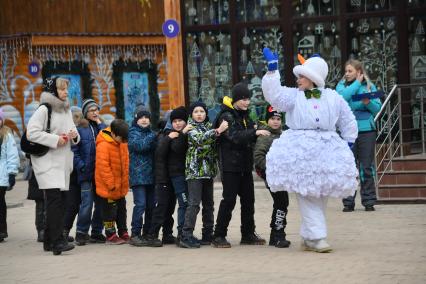 Москва.  Аниматор-снеговик во время развлекательной программы для детей  на открытии сезона в усадьбе Деда Мороза.