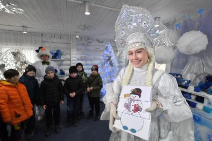 Москва.  Снегурочка во время развлекательной программы для детей  на открытии сезона в усадьбе Деда Мороза.