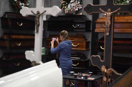 Москва. Посетительница на выставке погребальных принадлежностей, похоронного сервиса, мемориального искусства `Некрополь - WorldRussia 2022` в центральном выставочном комплексе `Экспоцентр`.